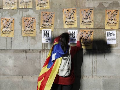 Un joven pega carteles en Barcelona para pedir la libertad de los ocho exconsellers encarcelados 