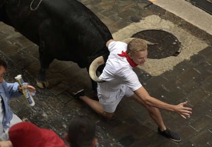 Un corredor es atropellado por uno de los toros.