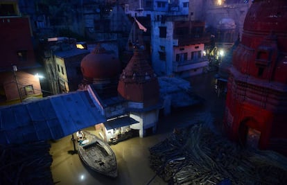 Un comerciante hindú observa su tienda inundada desde un barco en la ciudad de Varanasi (India).