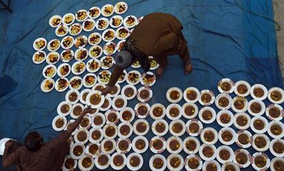 Los voluntarios paquistaníes preparan platos de alimentos 'Iftar' para que los residentes rompan su ayuno en Lahore, Pakistán.