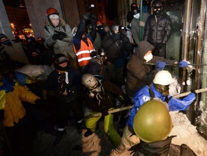 Manifestantes contra el Gobierno asaltan la Casa Ucrania, en el centro de Kiev, donde se hab&iacute;an refugiado los antidisturbios. 