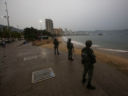 Three soldiers stand guard on a beach in Acapulco, before the arrival of Hurricane Otis.