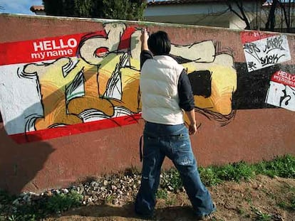 Un joven, ante un muro lleno de <i>graffiti</i> en Herrera Oria.