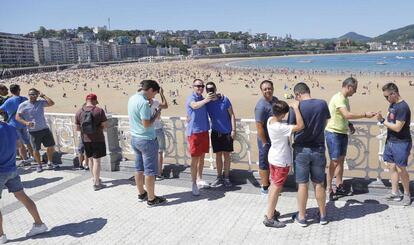 Turistas se hacen fotos en el paseo de La Concha de San Sebastián.