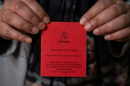 Tarjeta roja que acredita la condición de Anisa Yousaf como solicitante de asilo.