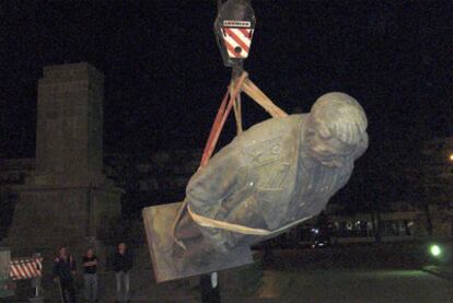 Unos operarios retiran la estatua de Stalin en la plaza central de Gori, en Georgia.