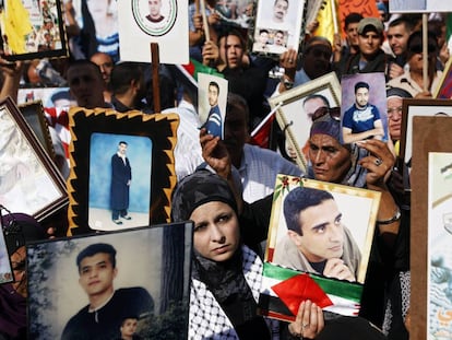 Palestinos sostienen imágenes de sus familiares presos en cárceles isralíes durante una protesta en Ramala, en la franja de Gaza, en 2022.