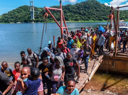 Migrantes, en su mayoría haitianos, atraviesan la presa "La Angostura" a bordo de barcos conocidos en la región como "Chalanes", en septiembre de 2021. 