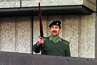 Sadam Husein dispara un fusil al aire durante un desfile militar en Bagdad en noviembre de 2000.