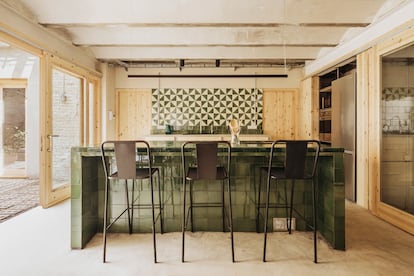 La cocina se concibe como un espacio de reunión por lo que se ha dispuesto una gran isla de obra revestida con cerámica vidriada en tonos verdes y campana integrada en la propia encimera.