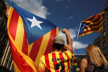 Un hombre sostiene una bandera estelada.