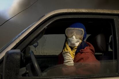 Un granjero de la localidad islandesa de Nupur, en su vehículo, con mascarilla y gafas para protegerse del humo.