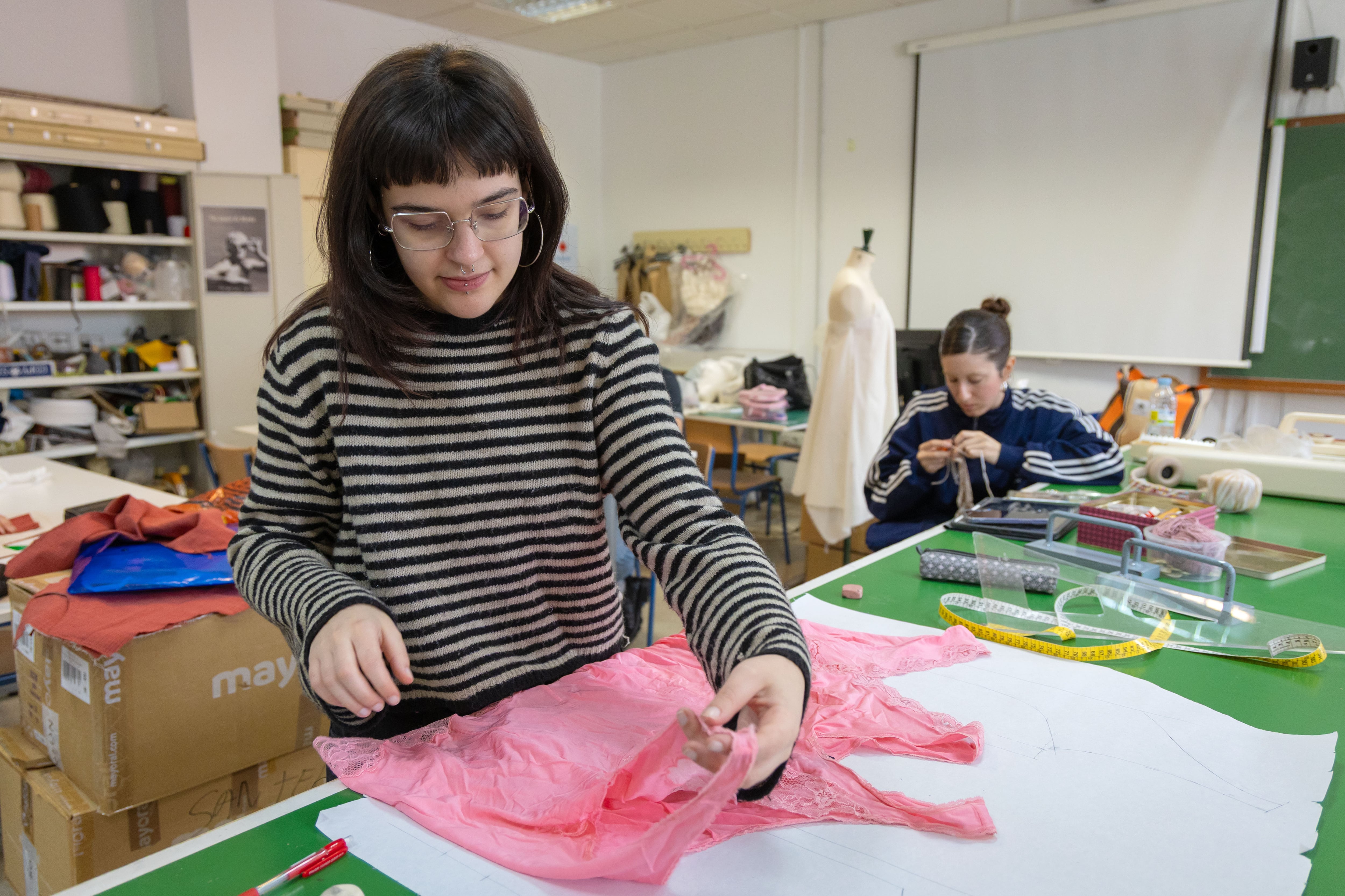 Dos estudiantes en el taller de diseño de moda.