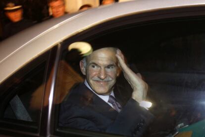 El jefe del Gobierno griego, Yorgos Papandreu, saluda tras abandonar, anoche, el palacio presidencial de Atenas.