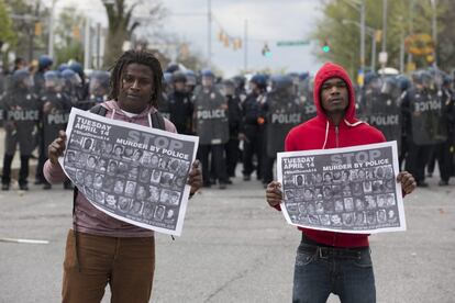 Jóvenes sostienen carteles que dicen 'Detengan el asesinato por policías' durante protestas después del funeral Freddie Gray este lunes.