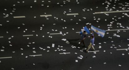 Dos seguidores del candidato argentino a la presidencia del Gobierno, Mauricio Macri, con dos banderas en Buenos Aires.