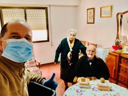 Uno de los repartidores de Serunion con una pareja de ancianos en Valencia tras entregar la comida del programa municipal Menjar a casa.