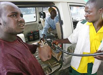El empleado de una gasolinera llena un bidón de combustible en Abuja, capital de Nigeria.