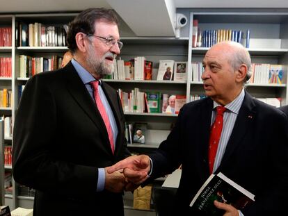 El expresidente del Gobierno Mariano Rajoy conversa con el exministro del Interior Jorge Fernández Díaz durante la presentación del libro de este último, ‘Cada día tiene su afán’.