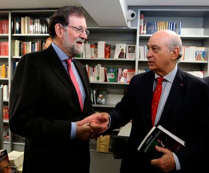 El expresidente del Gobierno Mariano Rajoy conversa con el exministro del Interior Jorge Fernández Díaz en una presentación de un libro en octubre de 2019 en Madrid.