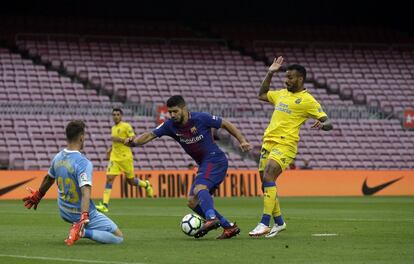 El portero de Las Palmas Leandro Chichizola trata de frustar una ocasión del delantero del Barcelona, Luis Suárez.