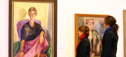 Dos mujeres observan los retratos de la exposición de Menchu Gal en Bilbao.