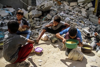 Ni?os del campo de refugiados de Jabalia comen alimentos distribuidos por ONGs, tras largas horas de cola. El fotgrafo palestino Mahmoud Issa ha recibido por su trabajo documental el premio de fotografa documental Luis Valtue?a, que concede la ONG Mdicos del Mundo. 