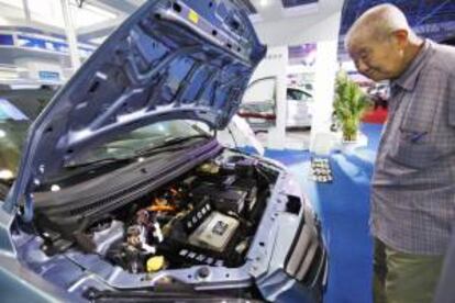 Un anciano observa el motor de un coche eléctrico exhibido en la Feria Internacional de Alta Tecnología de Pekín (China). EFE/Archivo