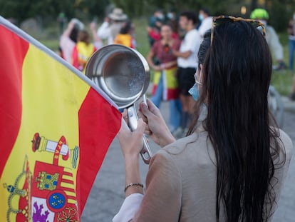 Una mujer golpea cacerolas en señal de protesta cerca de la vivienda del vicepresidente del Gobierno de España, Pablo Iglesias, y la ministra de Igualdad, Irene Montero.