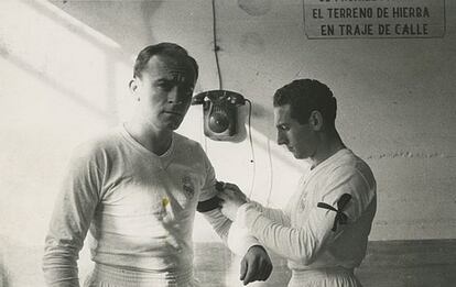 Paco Gento le coloca un brazalete negro a Alfredo Di Stéfano, en el vestuario del Real Madrid.