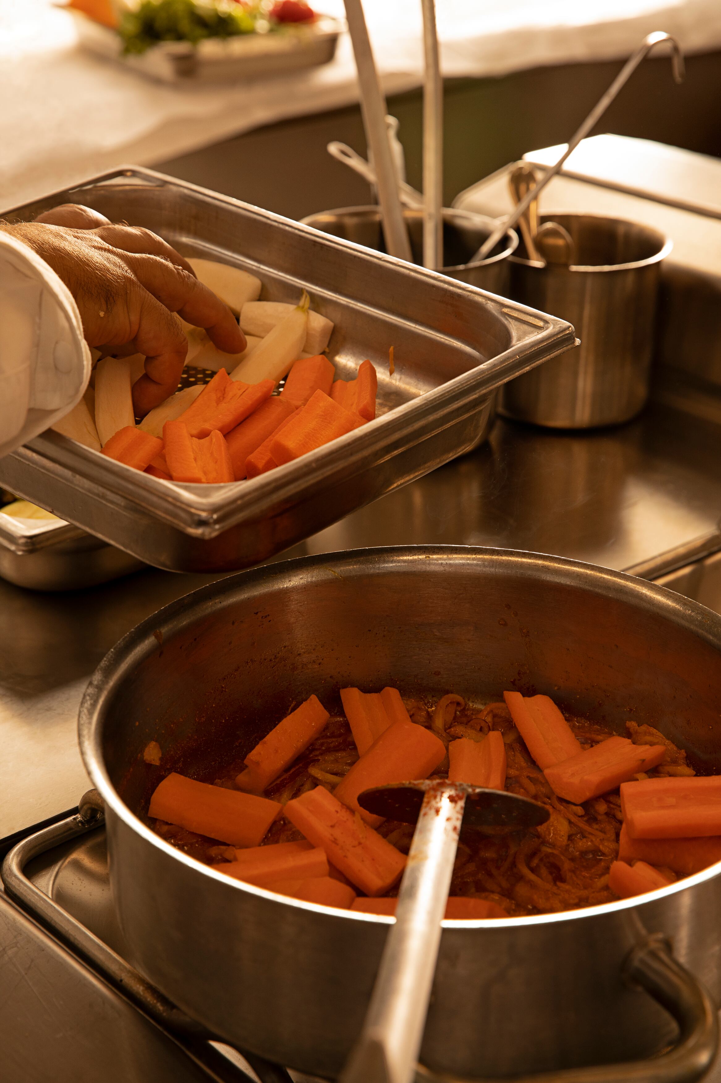 Se añaden las verduras cortadas a lo largo y se ponen a cocer, empezando por la zanahoria y los nabos. Cuando están a medio hacer se añade el tomate y el resto de las verduras. 