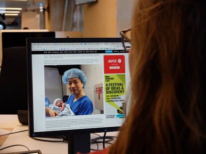 El doctor que realizó la operación, John Zhang, con el bebé recién nacido, en una imagen de 'New Scientist'.