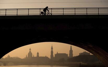 Un ciclista cruza el puente Marien al amanecer en Dresde (Alemania).