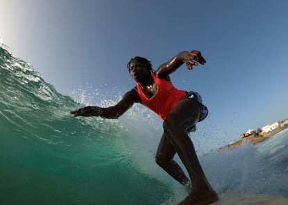 Khadjou Sambe, de 25 años, es la primera mujer surfista profesional de Senegal. En la imagen, practica surf durante una sesión de entrenamiento frente a la costa de Ngor, Dakar, Senegal, el 18 de agosto de 2020. Esta joven, que creció en la zona costera de Dakar, nunca vio a una mujer negra surfeando las olas del Atlántico. Como la primera surfista profesional femenina de Senegal, Sambe ahora está inspirando a la próxima generación a desafiar las normas culturales y lanzarse a las olas. "Cuando estoy en el agua siento algo extraordinario, algo especial en mi corazón", afirma.