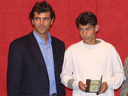 Rafa Nadal, en su época infantil, recoge un trofeo junto a su tío Miquel Àngel, ex futbolista.