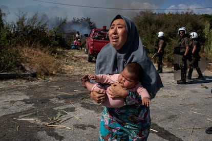 Una refugiada huye con su bebé en brazos del fuego originado en un campo cerca de Mitilene, capital de Lesbos. 