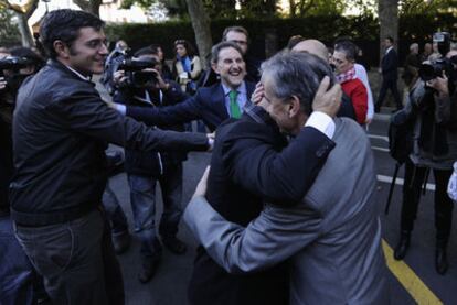 Ramón Jáuregui abraza a Odón Elorza en presencia de Eduardo Madina en el acto de homenaje a las víctimas.