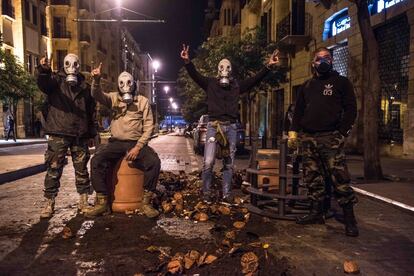 Cuatro jóvenes posan con máscaras de gas durante los violentos enfrentamientos entre manifestantes y fuerzas de seguridad libanesas, que dejaron docenas de heridos en la madrugada del domingo en Beirut, el 17 de diciembre.