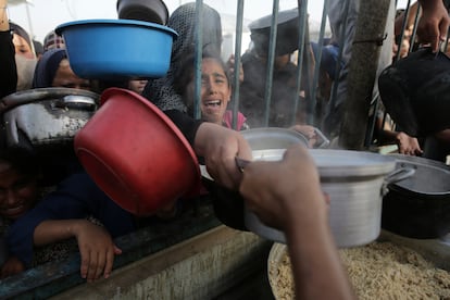 Una niña palestina recoge comida en Jan Yunis (Gaza) este domingo.