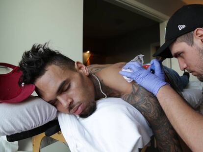 Fredy haciéndole un tatuaje al rapero Chis Brown