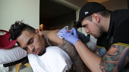 Fredy haciéndole un tatuaje al rapero Chis Brown