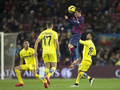 Messi salta a buscar una pilota al Camp Nou, envoltat de tres jugadors del Vila-real.