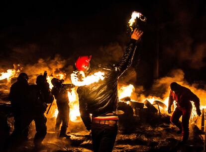 Un manifestante lanza un cóctel molotov durante los enfrentamientos con la policía antidisturbios.