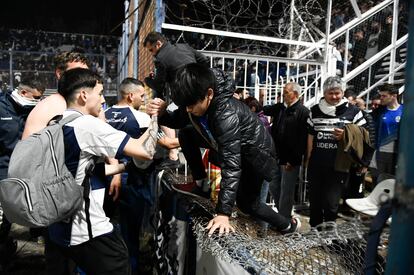 Varias personas ayudan a salir de las gradas a un grupo de aficionados, en el estadio de la ciudad de La Plata. Un fotógrafo fue herido por las balas de goma lanzadas por los agentes de policía y al menos un centenar de espectadores fueron llevados a hospitales de la zona tras los incidentes en los accesos al estadio. 
