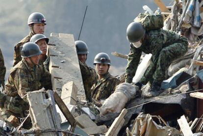 Un grupo de soldados recupera un cadáver entre las ruinas en Rikuzentakata, al norte de Japón.