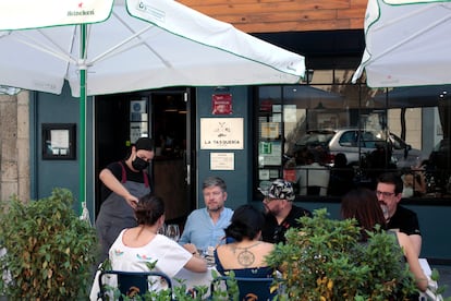 La jefa de sala, Ana Moya, sirve una mesa en la nueva terraza de La Tasquería.