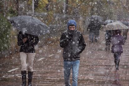 Además, las precipitaciones serán localmente fuertes o persistentes en el oeste de Galicia y no se descarta que lo sean en el extremo sur de Andalucía. En la imagen, un joven intenta protegerse de esta nevada por las calles de Vitoria.