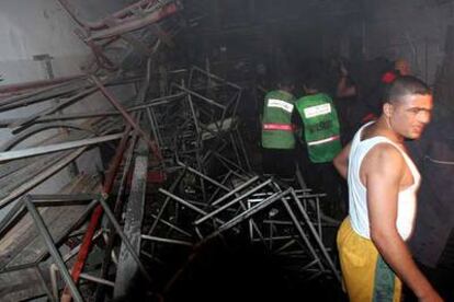 Palestinos inspeccionan el taller destruido en el campamento de refugiados de Al Shatea.