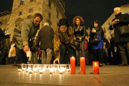 Varios de los asistentes a la concentración colocan velas por la libertad de expresión ante la sede de la Diputación de Valencia.
