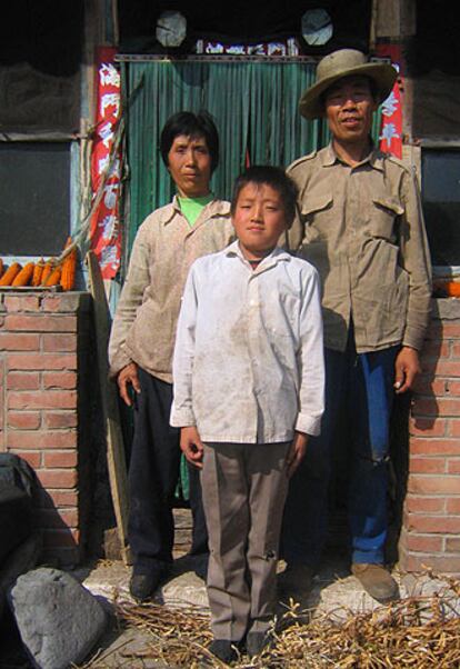 El matrimonio Wang, con un sobrino, delante de su casa en Nongzhong.